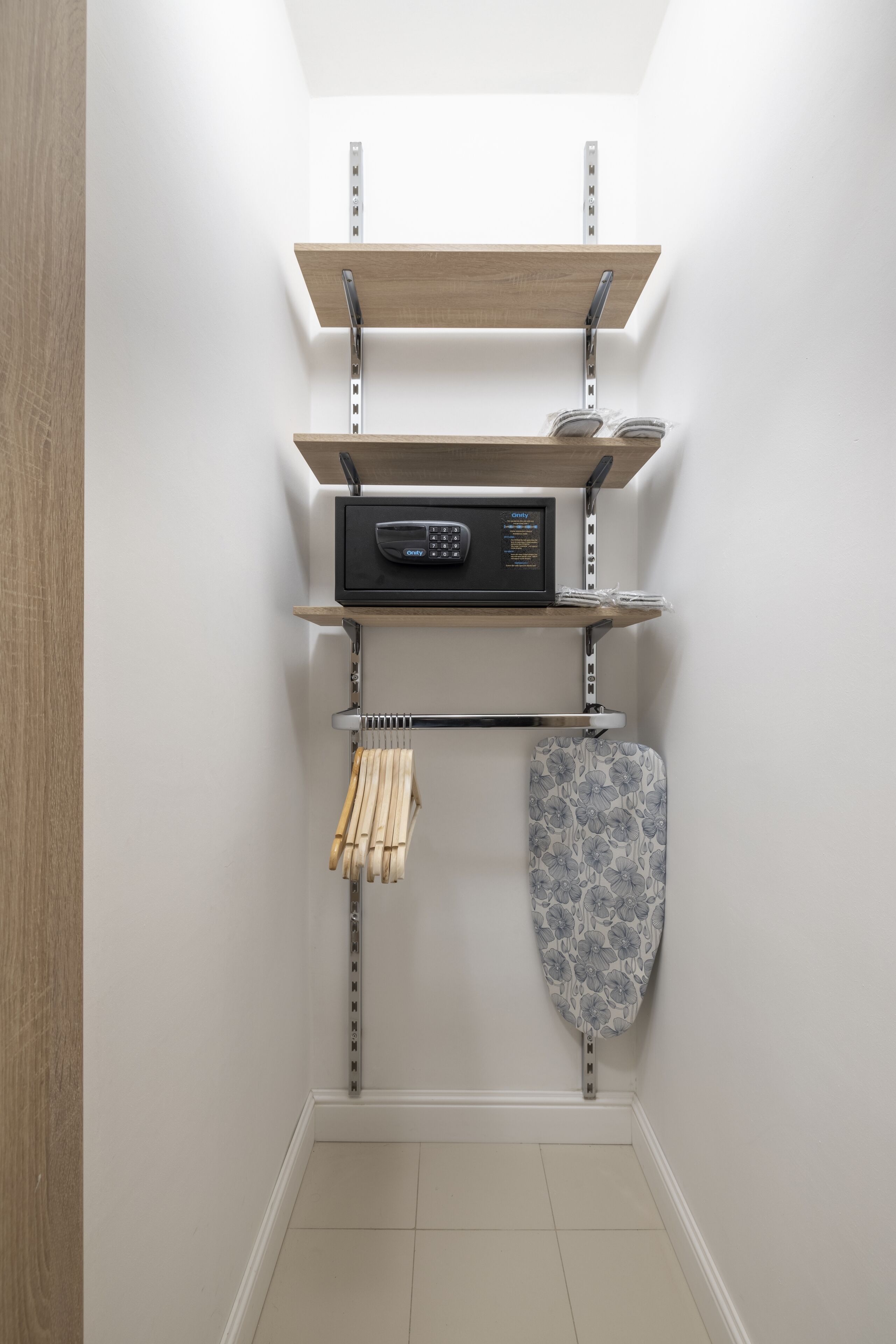 A corner storage unit with shelves, a radio, and a hanging laundry rack.