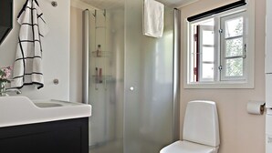 A bathroom with a white sink, a glass shower enclosure, a toilet, and a window with curtains. - Österlen, fantastic cozy guesthouse for Villa Veranda (Ystad M)