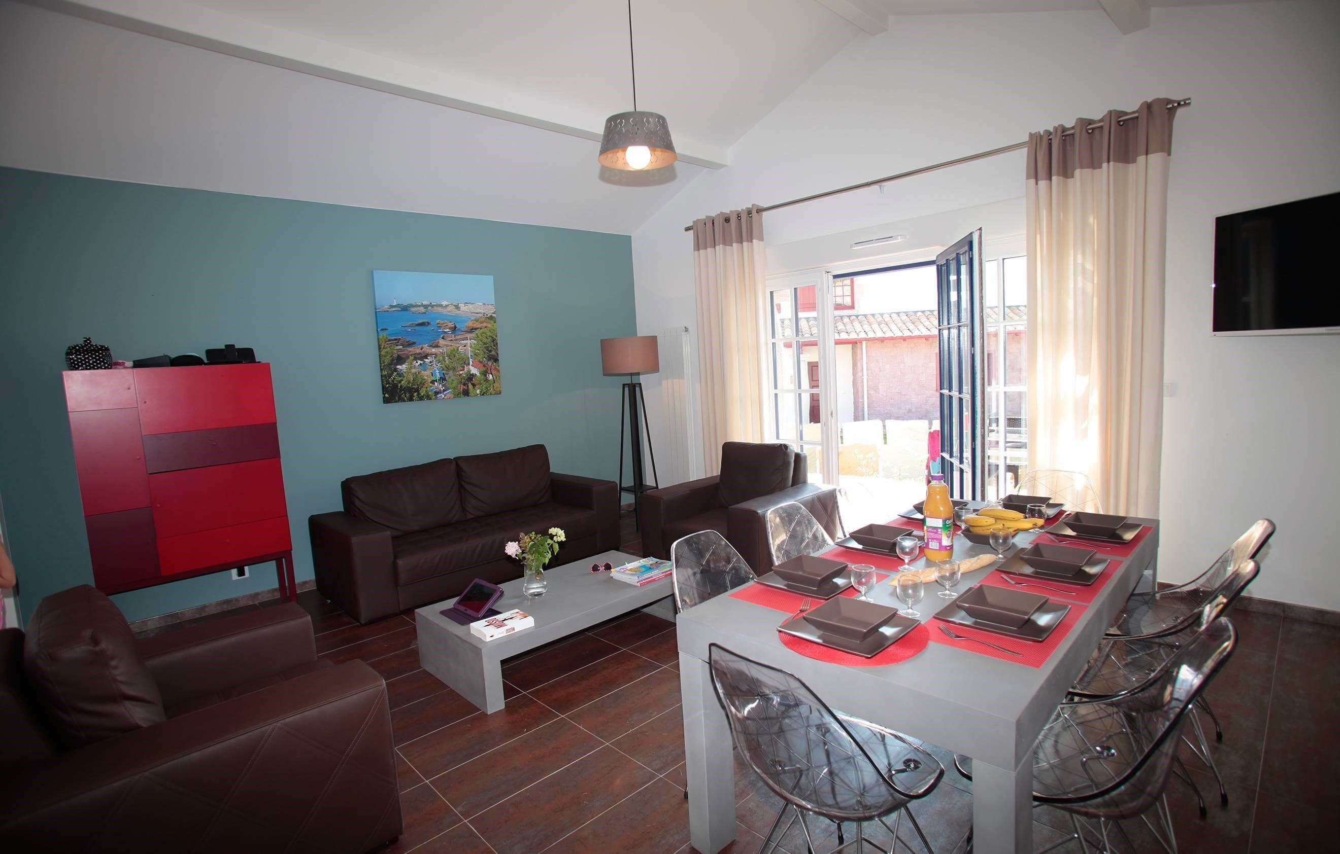 A modern living room with a dining area, featuring a sofa set, a coffee table, and a dining table set for four.