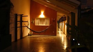 A hallway with a hammock, a potted plant, and a lit wall. - At Casa em Ubatuba - Praia do Itaguá, excellent for families and long stays. (Ubatuba)