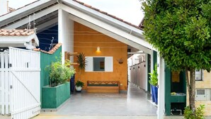 A covered outdoor area with a bench, potted plants, and a tiled floor. - At Casa em Ubatuba - Praia do Itaguá, excellent for families and long stays. (Ubatuba)