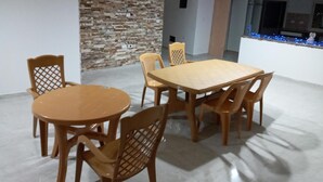 A dining area with a round table and six chairs, a brick wall, and pendant lighting. - Chez William (Bethlehem)