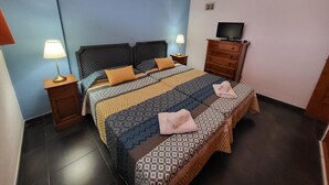 A hotel room with a bed, two bedside tables with lamps, a TV on a dresser, and a small picture on the wall. - Summerland 3 (Los Cristianos)
