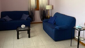 A living room with two blue sofas, a small table, and a lamp. - semi-detached house n residential area (Quartu Sant'Elena)