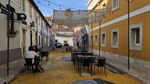 A narrow street with outdoor seating and a mural on the ground. - Historic Center Cascais Bolina 1 (Cascais)