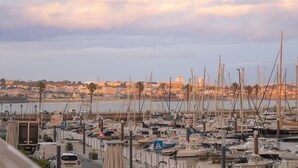 A marina with numerous boats docked, a cityscape in the background, and a clear sky. - Historic Center Cascais Bolina 1 (Cascais)