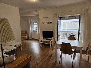 Relax in this stylish living room with a flat-screen TV, dining area, and comfortable sofa.