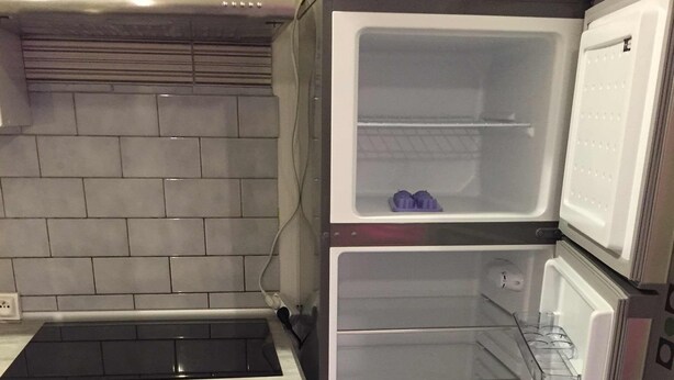 Una cocina compacta con estufa integrada, refrigerador y lavaplatos.