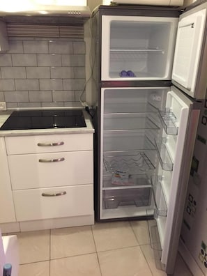 A compact kitchen with a built-in stove, a refrigerator, and a sink.