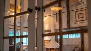Ein gemütlicher Innenraum mit Kamin, Holzwänden und einer Chandelier.