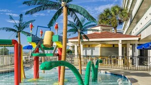 A water park with colorful play structures, palm trees, and a building with a red roof. - July 4th Week - Ocean Front 1 Bedroom Deluxe Westgate Myrtle Beach Resort (Myrtle Beach)