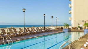 A poolside area with lounge chairs and a view of the ocean. - July 4th Week - Ocean Front 1 Bedroom Deluxe Westgate Myrtle Beach Resort (Myrtle Beach)