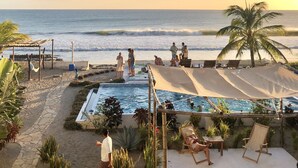 A poolside area with lounge chairs, a small pool, and a view of the ocean. - Costa Oeste (Popoyo)