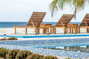 Una piscina al aire libre, tumbonas