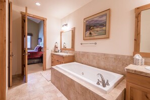 Tina con regadera, tina de hidromasaje, secadora de cabello, toallas 