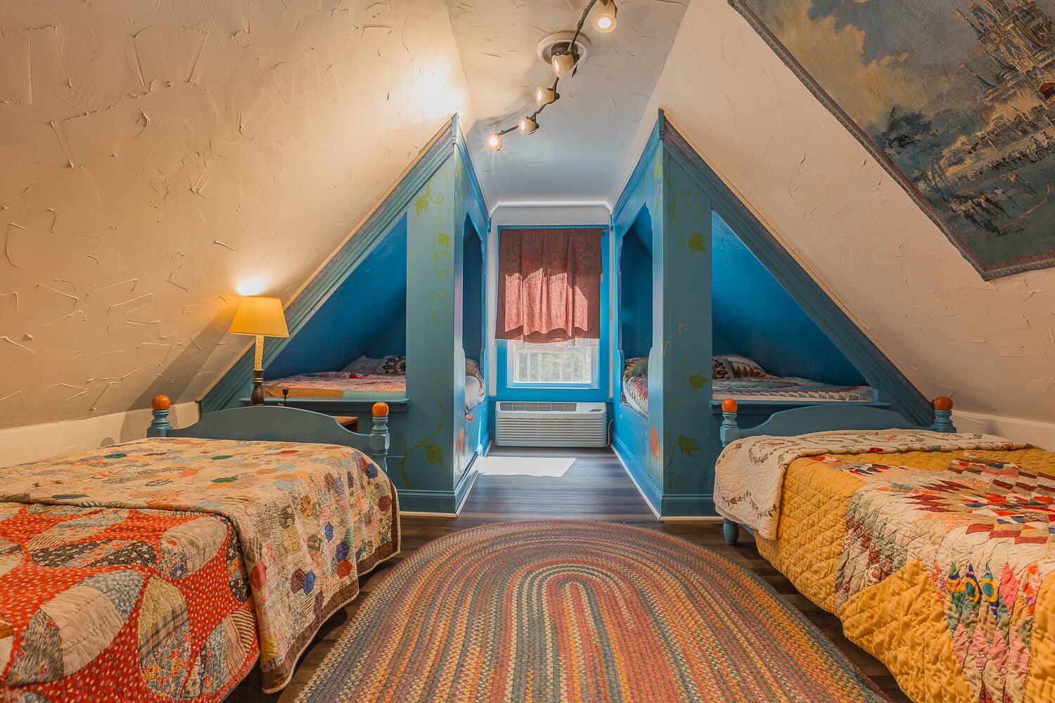 Una habitación con dos camas, una ventana con cortinas, una alfombra estampada y una lámpara de techo.
