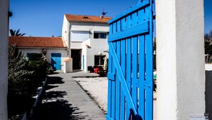 Un sendero estrecho que lleva a un edificio con una puerta azul.