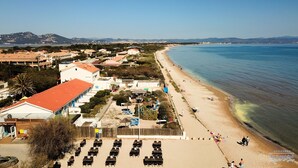 Un hotel frente al mar con acceso directo a la playa, mobiliario exterior y vistas al océano.