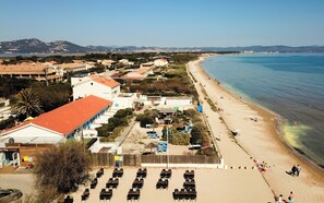 Ein Küstenhotel mit direktem Strandzugang, Sitzgelegenheiten im Freien und Meerblick.