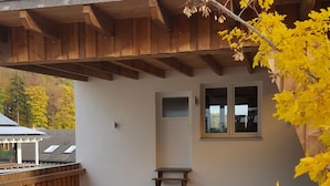 Ein Gebäude mit einer Holzveranda, einer kleinen Treppe und einem Fenster.