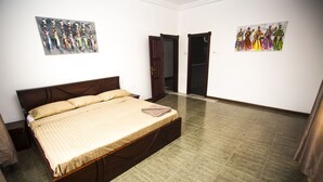Ein Schlafzimmer mit einem Bett, zwei Türen und zwei an der Wand befestigten Bildern.