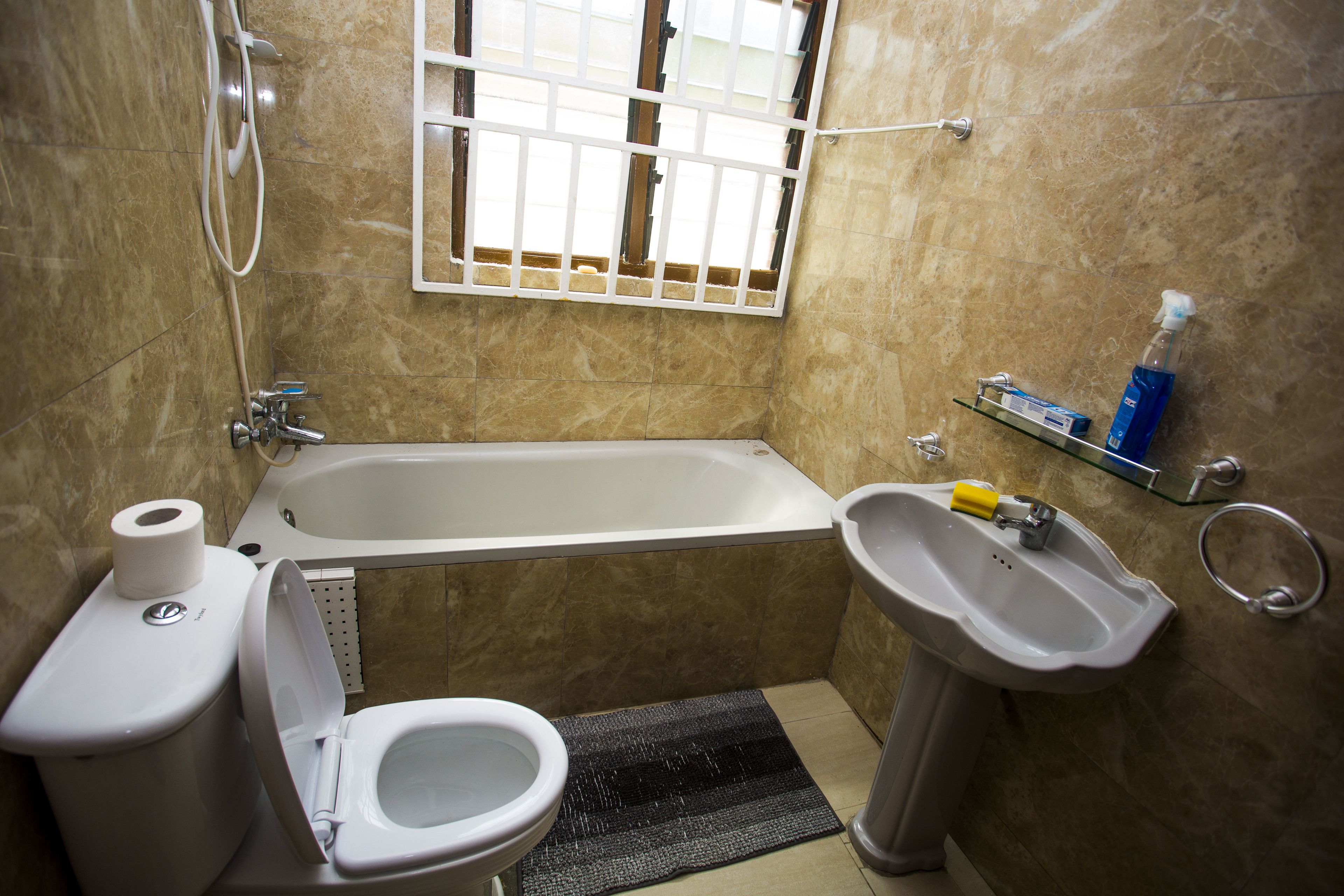 Un baño con inodoro, lavamanos y bañera.