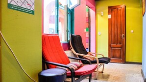 A waiting area with two chairs, a wooden door, and a tiled floor. - Funky Mamaliga Hostel (Chisinau)