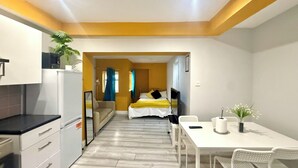 A modern hotel room with a kitchenette, a dining area, and a bed. - King’s Cross Apartment Ground floor  (London)