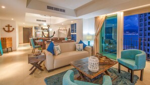 A spacious living room with a sofa, armchairs, and a coffee table. There is a dining area with chairs and a table, and a kitchen in the background. - BEACHFRONT & TERRACE CONDO! (Puerto Vallarta)