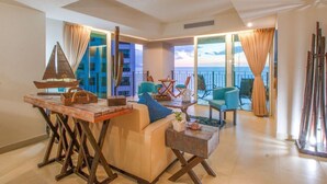A spacious living area with a sofa, coffee table, and a view of the sea through large windows. - BEACHFRONT & TERRACE CONDO! (Puerto Vallarta)