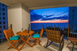 Enjoy breathtaking ocean views from this balcony with a round table and comfortable seating for four.