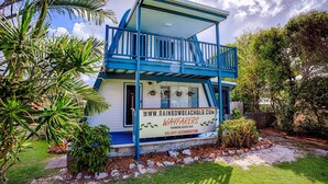 A two-story building with a blue exterior and a balcony. - Wayfarers Beachouse - Rainbow Beach. Everything you need, just metres to the beach. Pets welcome (Rainbow Beach)