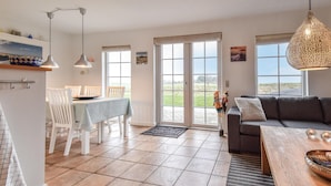A spacious living area with a dining table, a sofa, and a kitchen area with a window. - Beautiful home in Brenderup Fyn (Brenderup Fyn)