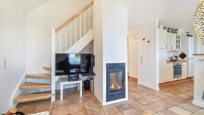 A modern living room with a fireplace, a television, and a staircase. - Beautiful home in Brenderup Fyn (Brenderup Fyn)