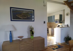 Un salon moderne avec un meuble en bois, une lampe bleue, un bol décoratif et un tableau encadré accroché au mur.