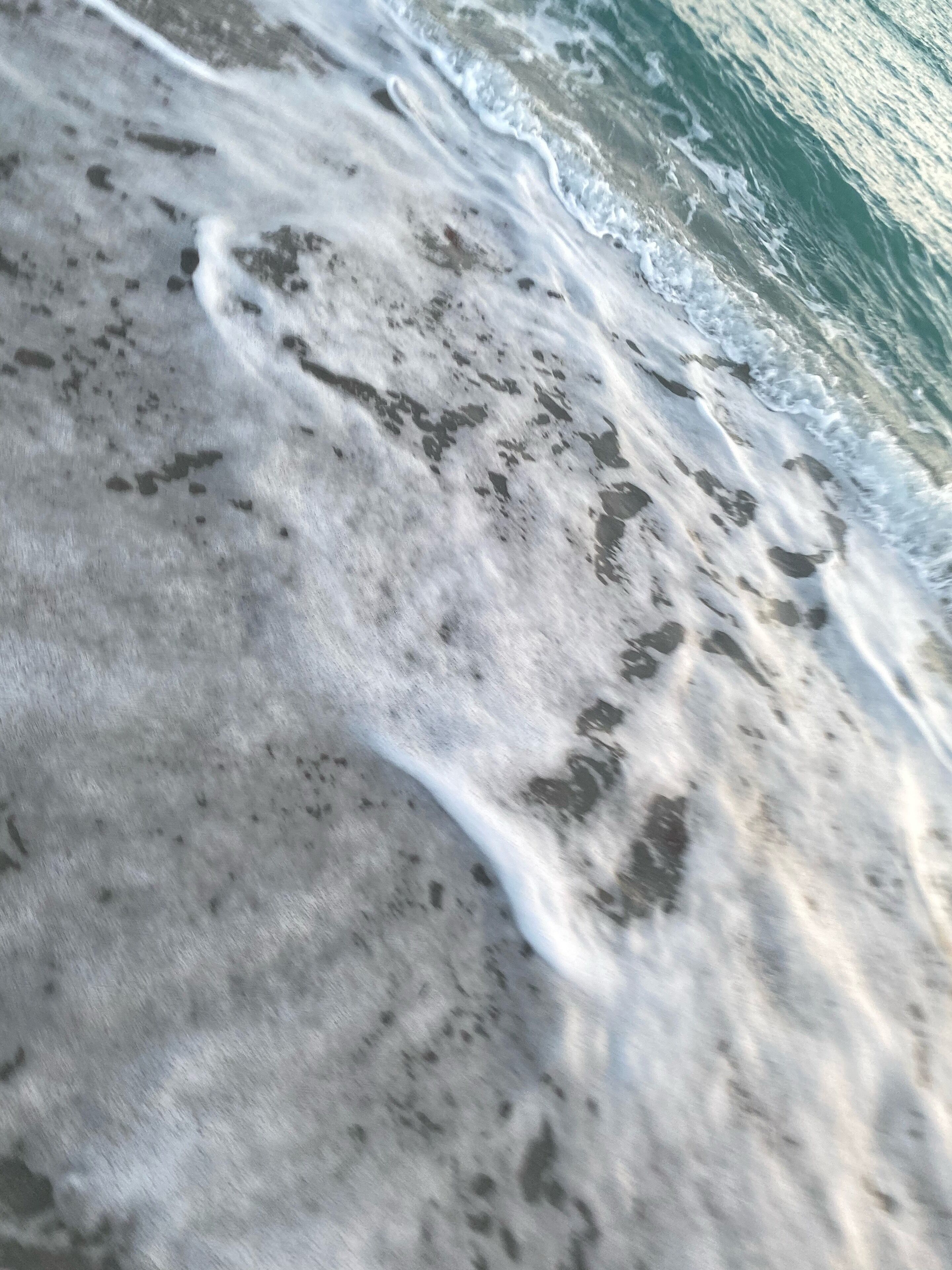 Un gros plan d’une plage de sable avec des vagues.