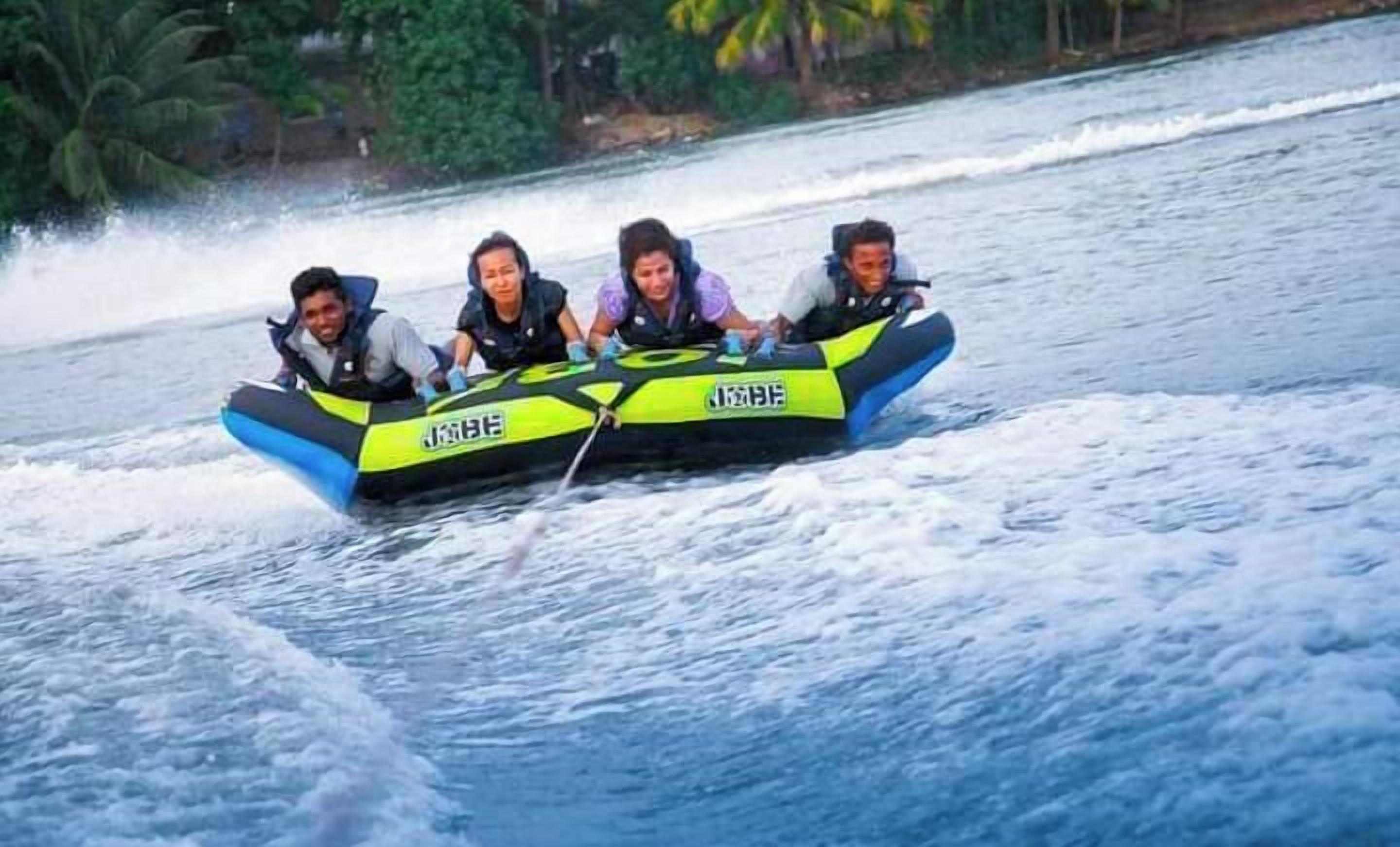 A group of people on a watercraft with the text "JETBOAT" on it.