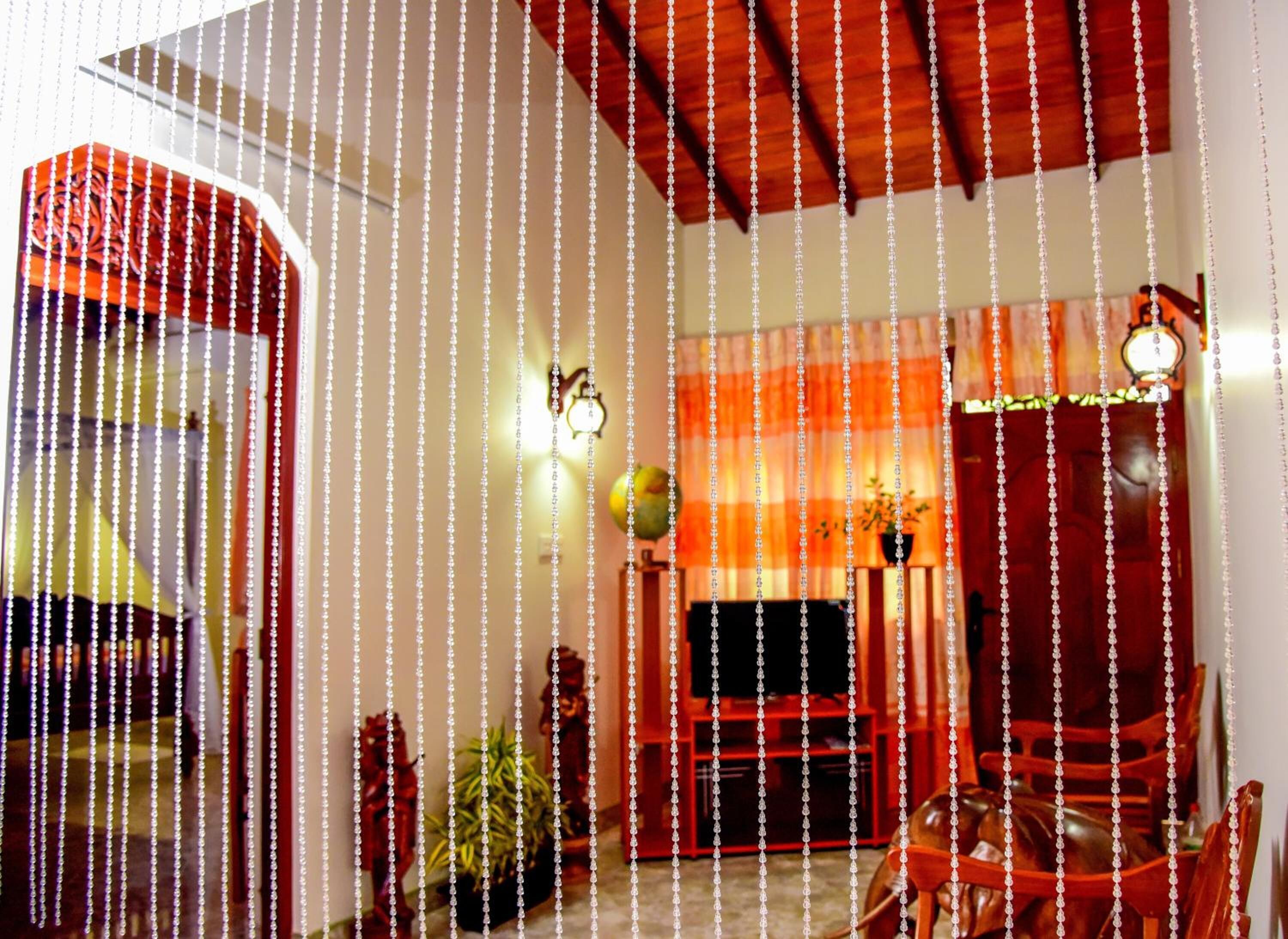 A room with a red and orange color scheme, a flat-screen TV, and a seating area with chairs and a table.