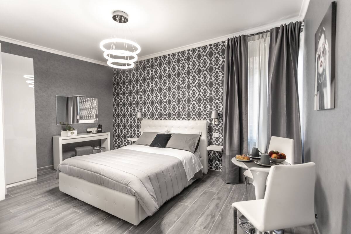 Une chambre moderne avec un grand lit, des tables de chevet, un bureau et une chaise.