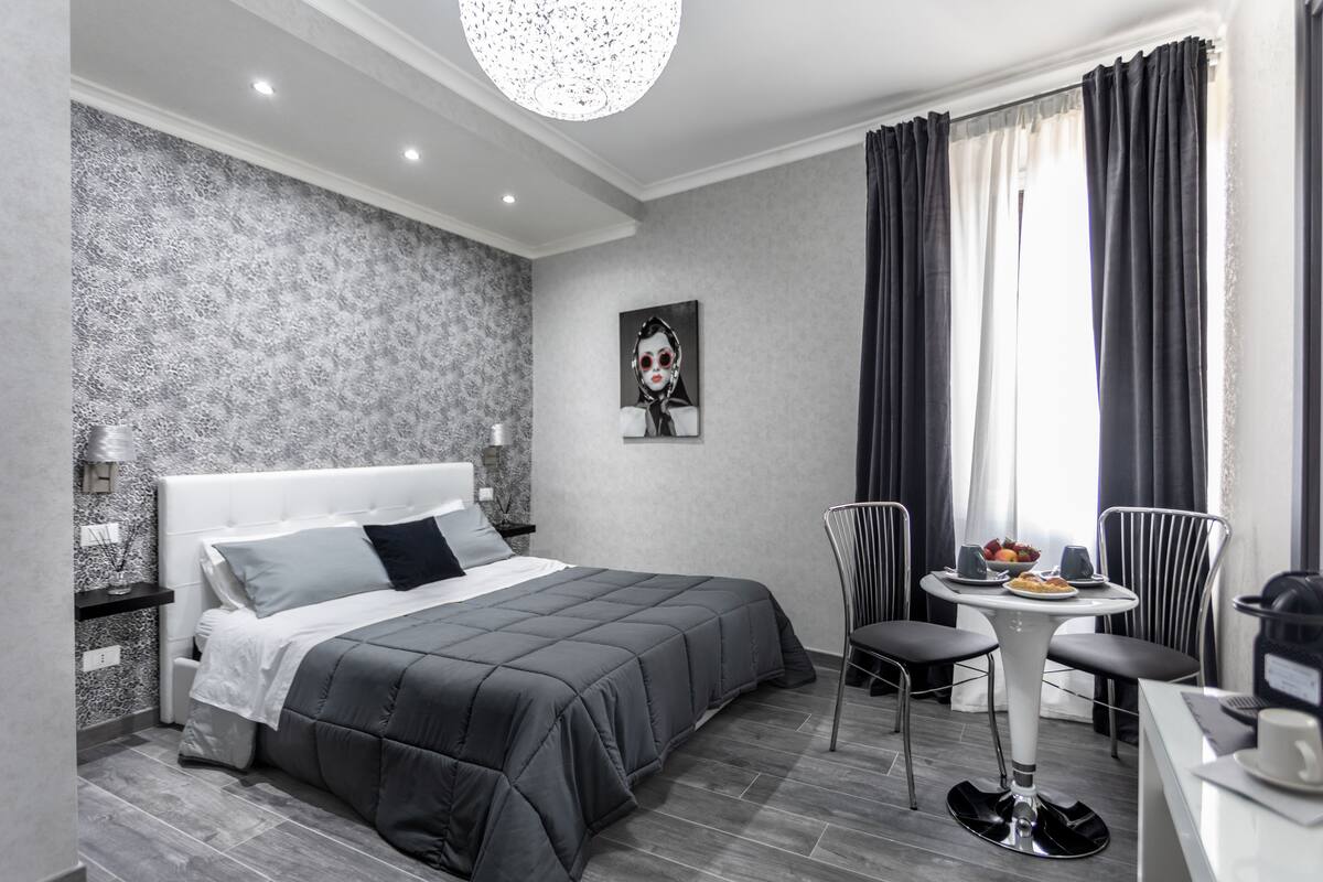 Une chambre d’hôtel moderne avec un grand lit, une petite table à manger et une chaise.