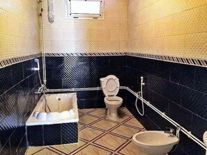 A bathroom with a bathtub, toilet, and bidet. - La Résidence Location Daoud (Souk El Tenine)