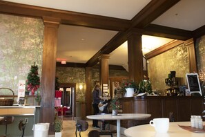 A cozy restaurant interior with wooden beams, a Christmas tree, and a coffee bar. - Hotel Hartington (Hartington)