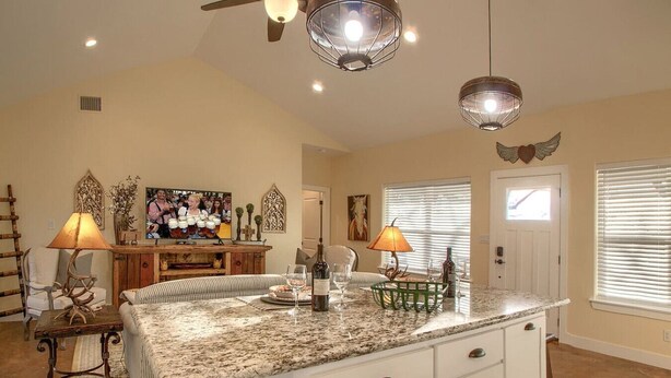 A spacious living area with a large island, a television, and decorative items.
