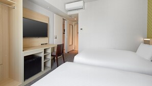 A hotel room with a bed, a desk with a flat-screen TV, a wardrobe, and a built-in air conditioning unit. - Sotetsu Fresa Inn Osaka-Namba (Osaka)
