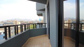 Ein Balkon mit Blick auf eine Stadtlandschaft und Berge.