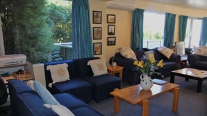 A living room with blue sofas, a wooden coffee table, and a vase with flowers. - Jewel in Tata Beach. (Tata Beach)
