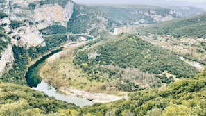 A river winding through a mountainous landscape with dense vegetation and rocky cliffs. - Équipé avec Terrasse, vue sur l'Ardèche! (VALLON-PONT-D’ARC)