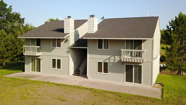 A two-story house with a balcony on the second floor, a chimney, and a staircase leading to the upper level. - 14 - Clean, Comfortable and Quiet Condo at the base of Jackson Creek Summit (Wakefield)