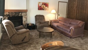 A living room with a stone fireplace, a couch, two armchairs, a coffee table, and a lamp. - 14 - Clean, Comfortable and Quiet Condo at the base of Jackson Creek Summit (Wakefield)