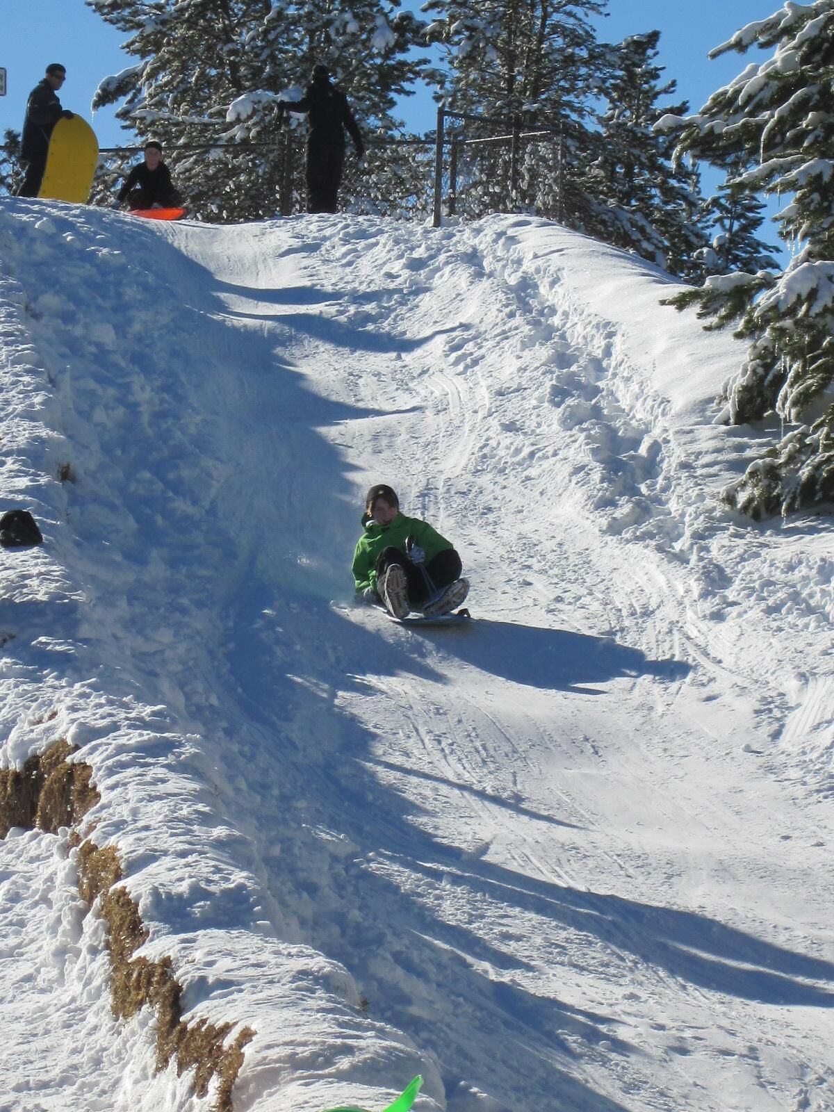 Une pente enneigée sur laquelle une personne descend en faisant du snowboard.